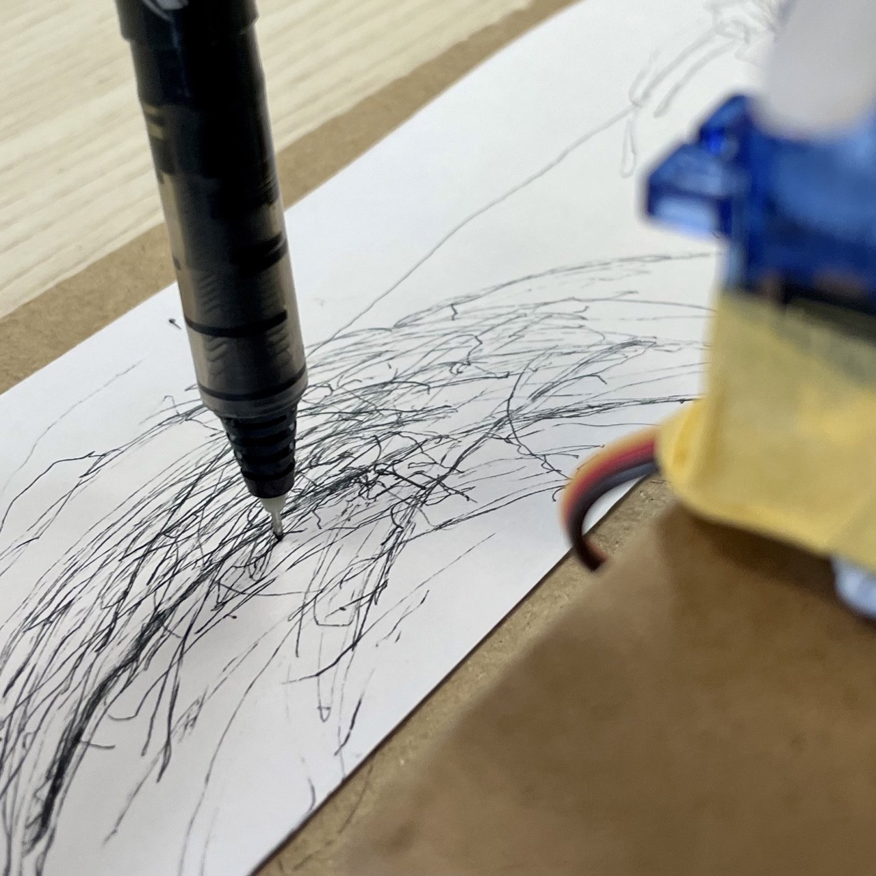 Drawing machine in action on a long strip of paper
